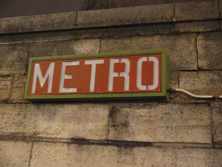 Lit metro sign on a wall